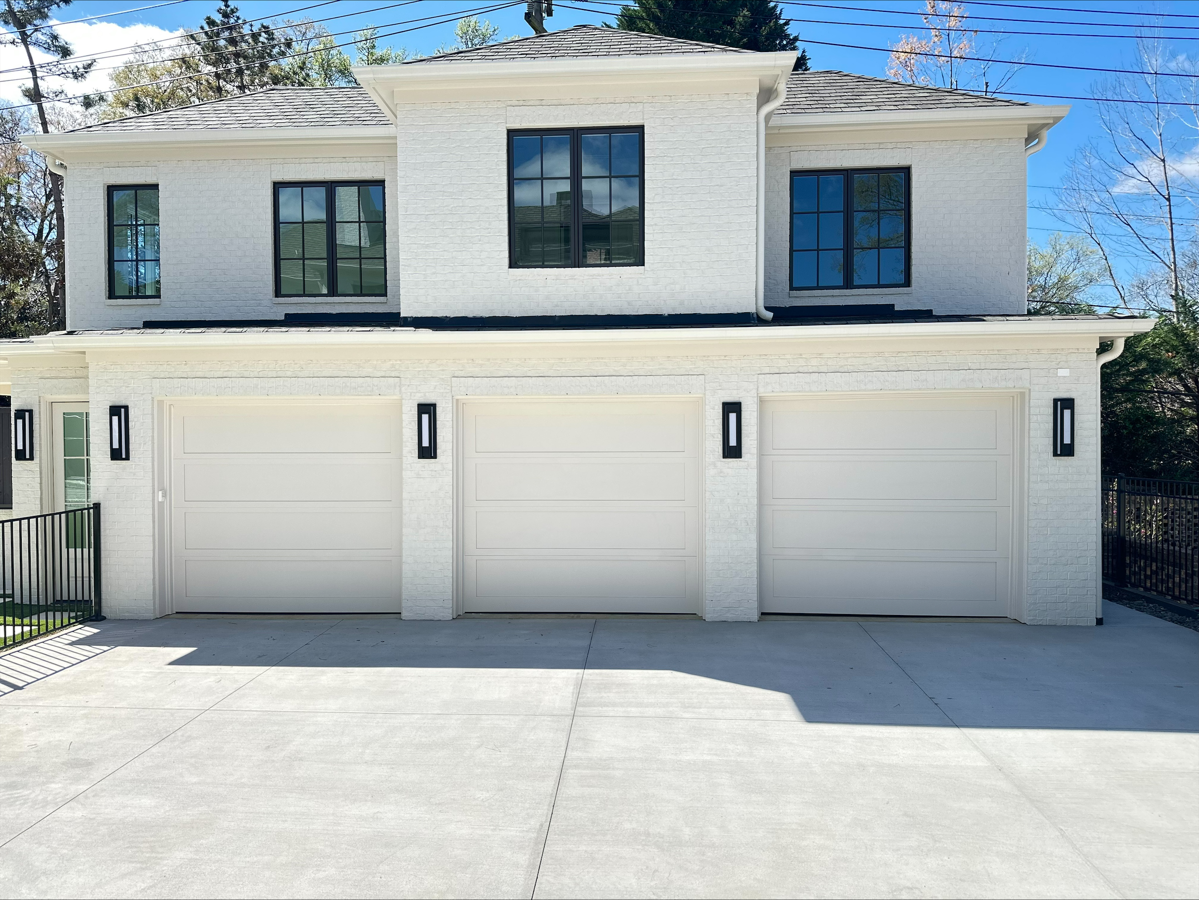 DURA-EEZ composite garage doors in white and black, installed on a modern home.